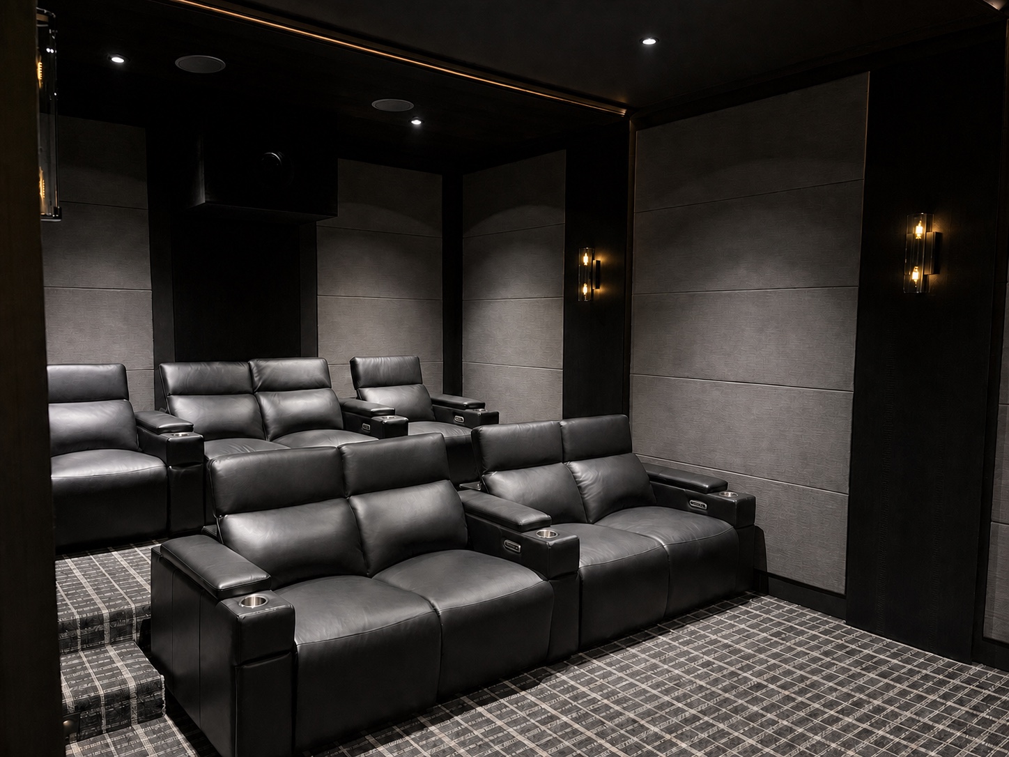 Tiered black leather theater seating surrounded by acoustic panels
