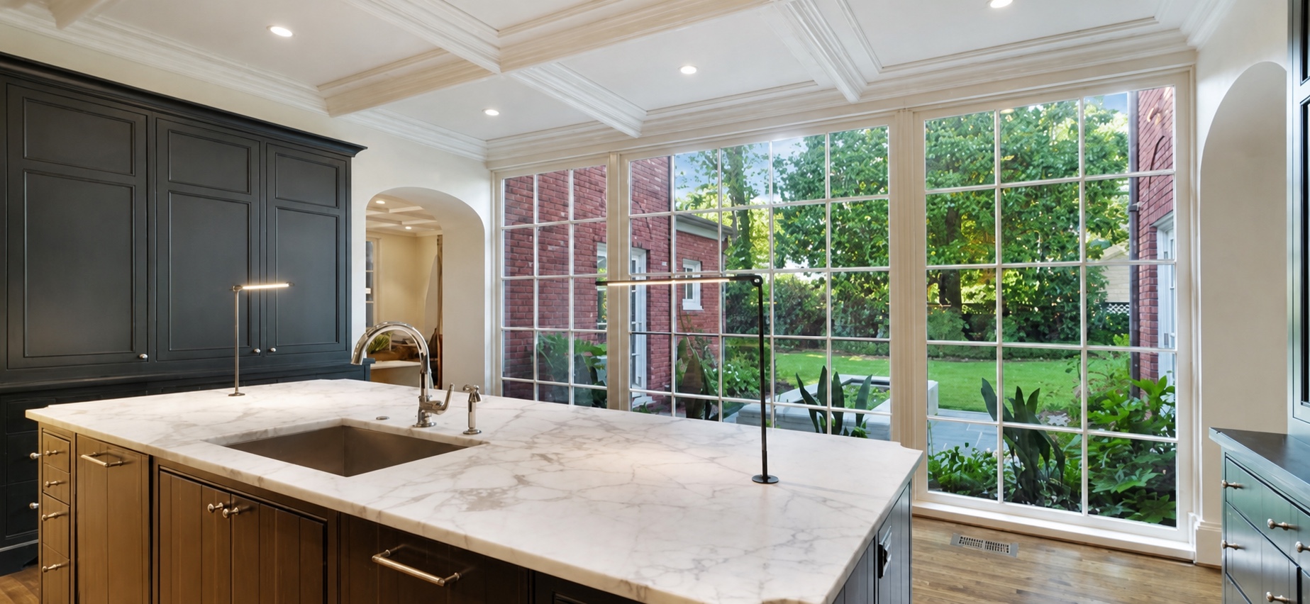 Kitchen island framed by expansive garden windows