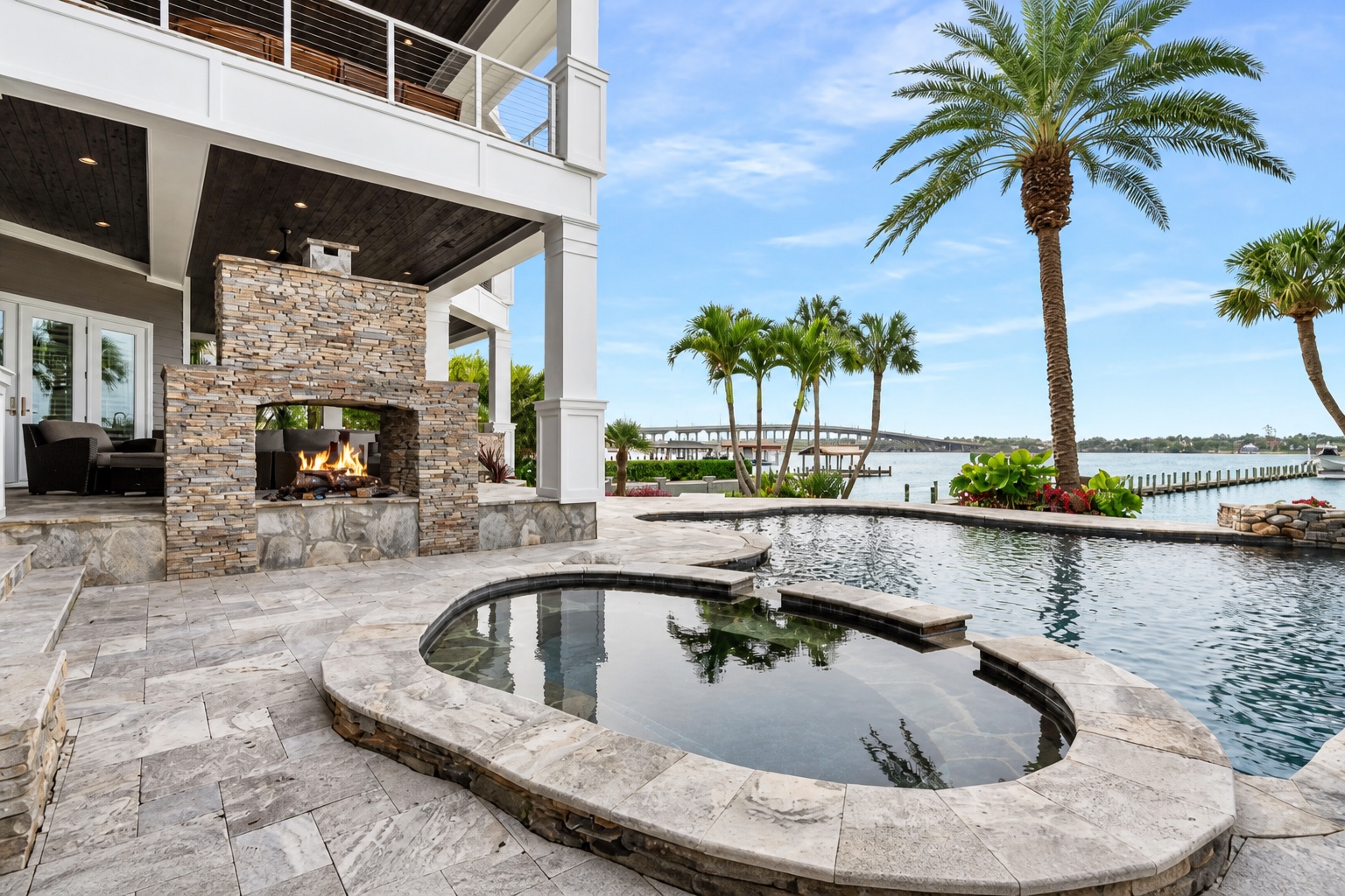 Waterfront pool, spa, and outdoor fireplace at the Ormond Beach residence