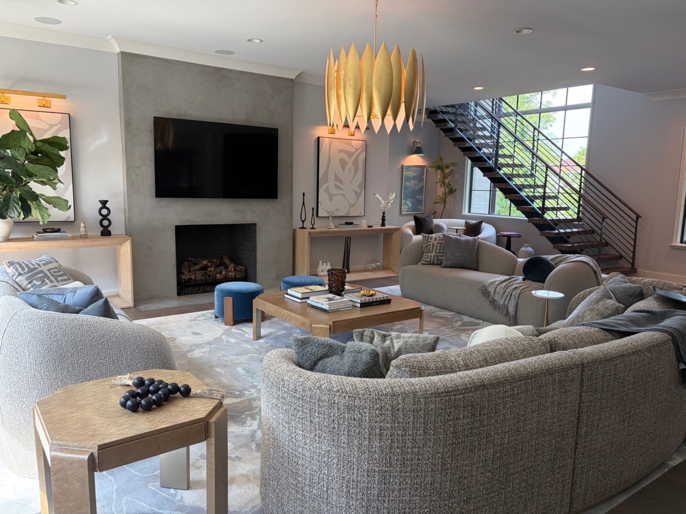 Contemporary living room with integrated television, fireplace, and open stair