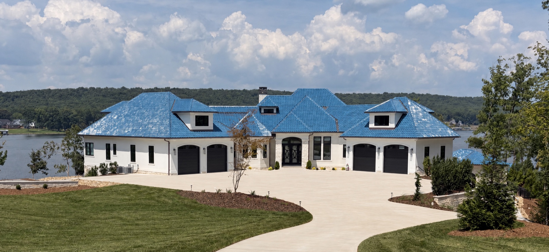 Lake Tillery lakefront residence with a blue roof and curving driveway